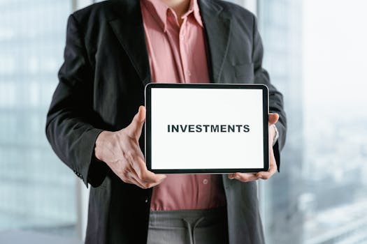 Fig. 1 Professional holding a tablet with 'INVESTMENTS' text, ideal for finance and business themes.